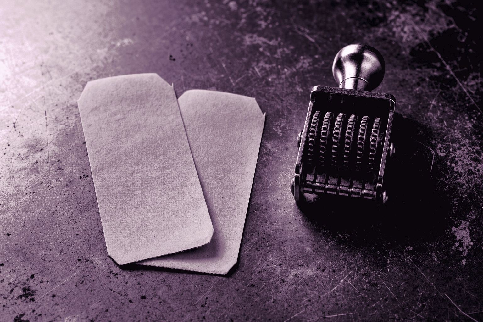 Two blank unprinted transfer slips lying overlapped beside a rubber date stamp with an unset type wheel